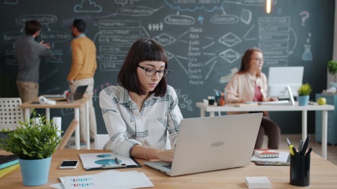 Professional using an AI tool on a laptop in a modern office