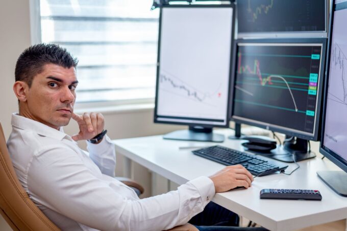 Finansal piyasa verilerini çoklu ekranlarda analiz eden yatırım profesyoneli