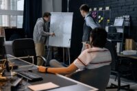Startup ekibinin beyaz tahta üzerinde stratejiyi gözden geçirdiği toplantı
