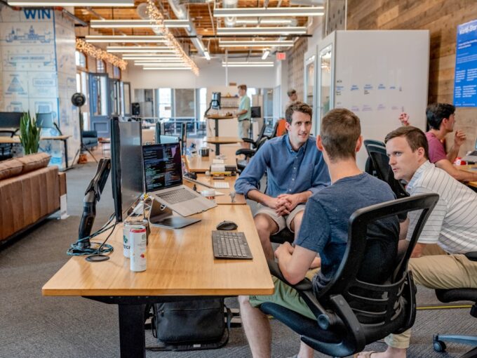 Startup founders reviewing strategy around a whiteboard